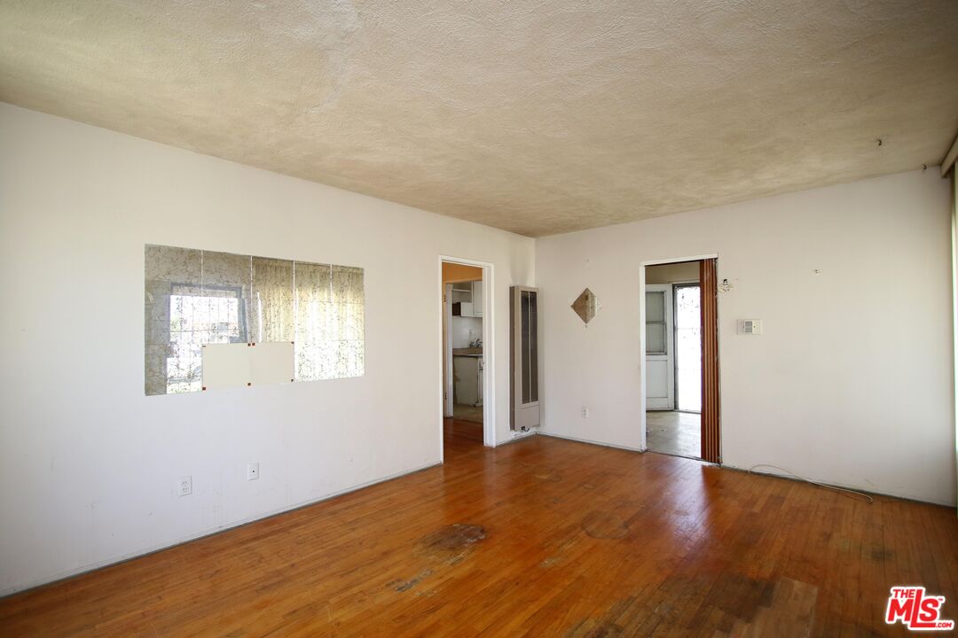 1022 West 156th Street Compton, CA 90220 - Photo 5 of 24 a view of an empty room with wooden floor and a window