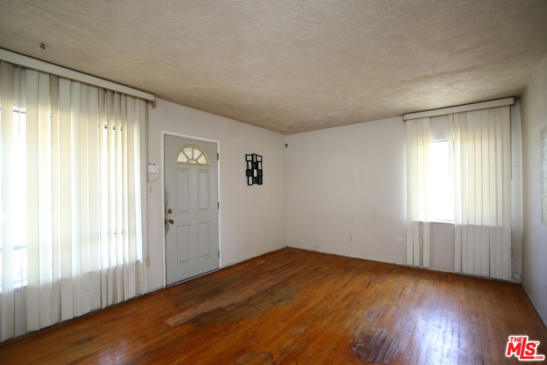 1022 West 156th Street Compton, CA 90220 - Photo 6 of 24 an empty room with wooden floor and windows