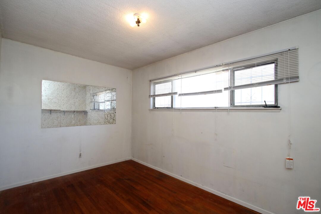 1022 West 156th Street Compton, CA 90220 - Photo 9 of 24 an empty room with wooden floor and windows