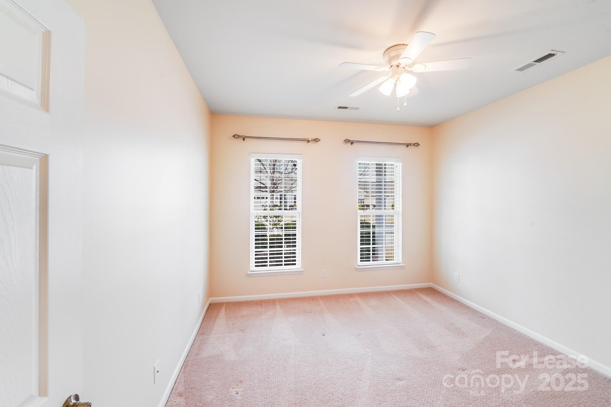 7012 Kitty Hawk Lane Fort Mill, SC 29707 - Photo 22 of 46 an empty room with windows and chandelier fan