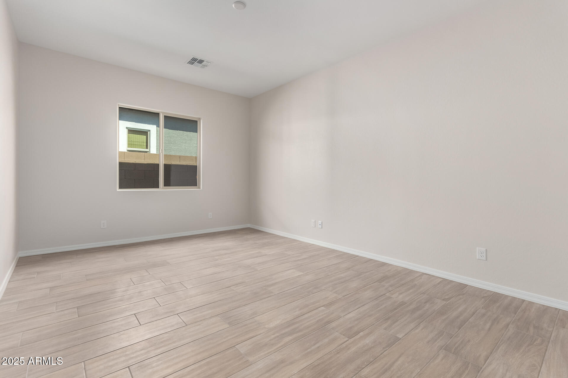 4818 West Capistrano Avenue Laveen, AZ 85339 - Photo 21 of 44 an empty room with wooden floor and windows
