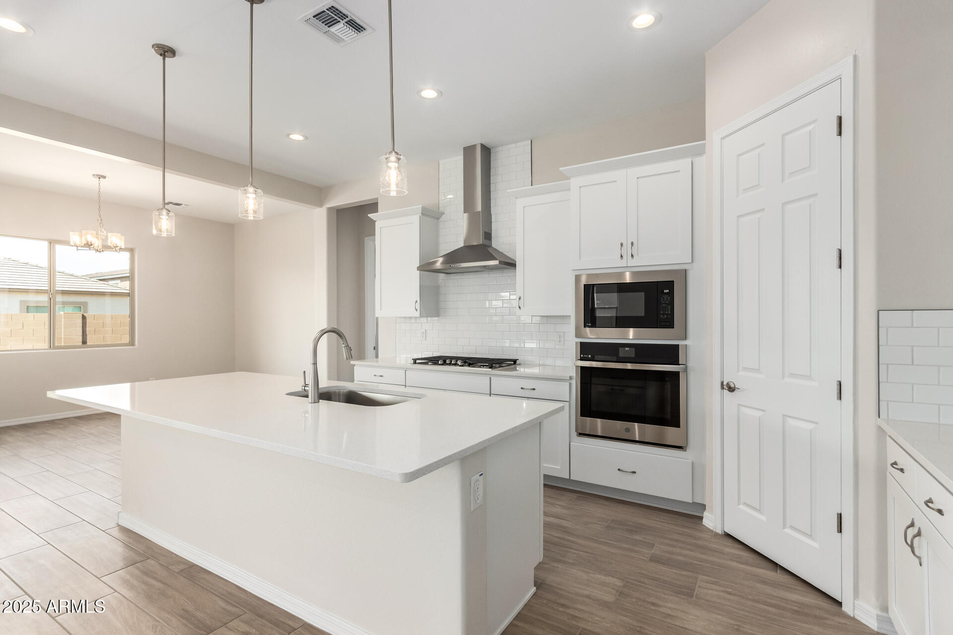 4818 West Capistrano Avenue Laveen, AZ 85339 - Photo 2 of 44 a kitchen with stainless steel appliances granite countertop a sink stove a refrigerator and white cabinets with wooden floor
