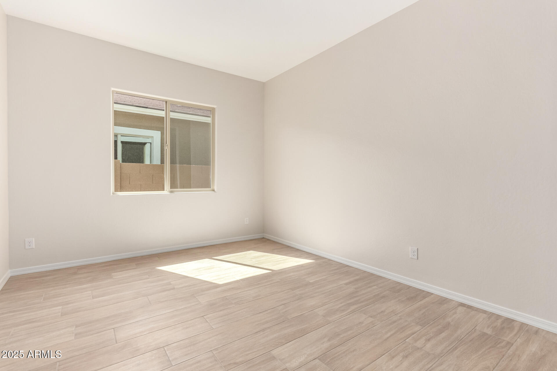 4818 West Capistrano Avenue Laveen, AZ 85339 - Photo 33 of 44 a view of an empty room with wooden floor and a window