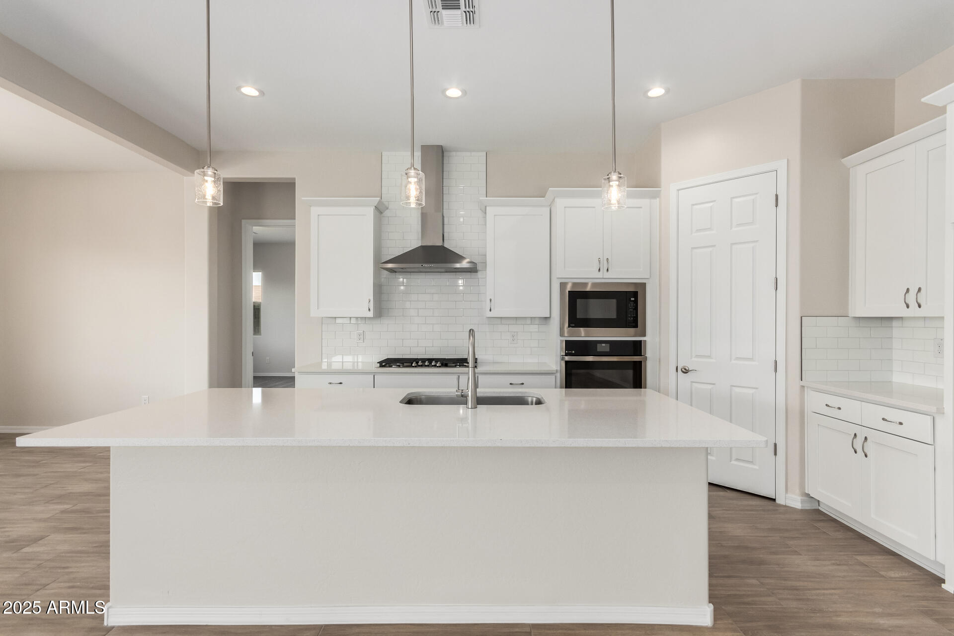 4818 West Capistrano Avenue Laveen, AZ 85339 - Photo 3 of 44 a large kitchen with kitchen island a sink stainless steel appliances and white cabinets