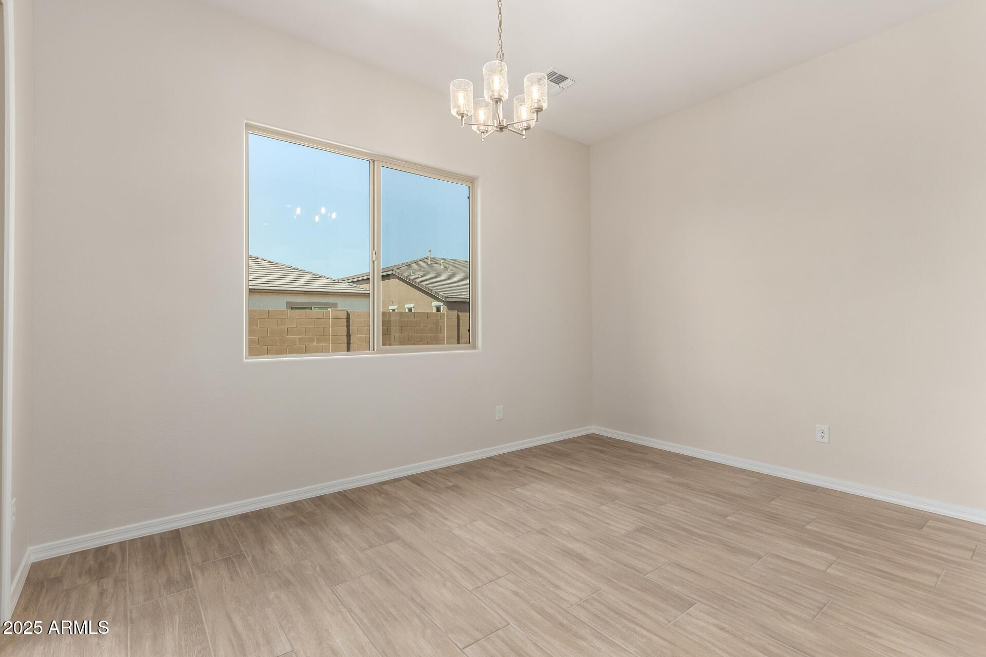 4818 West Capistrano Avenue Laveen, AZ 85339 - Photo 7 of 44 wooden floor in an empty room with a window
