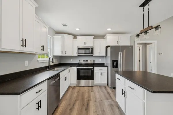 a large kitchen with cabinets stainless steel appliances and a counter space