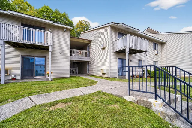 a view of a house with a yard and porch