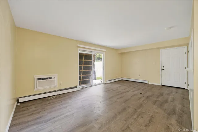 an empty room with wooden floor and white walls