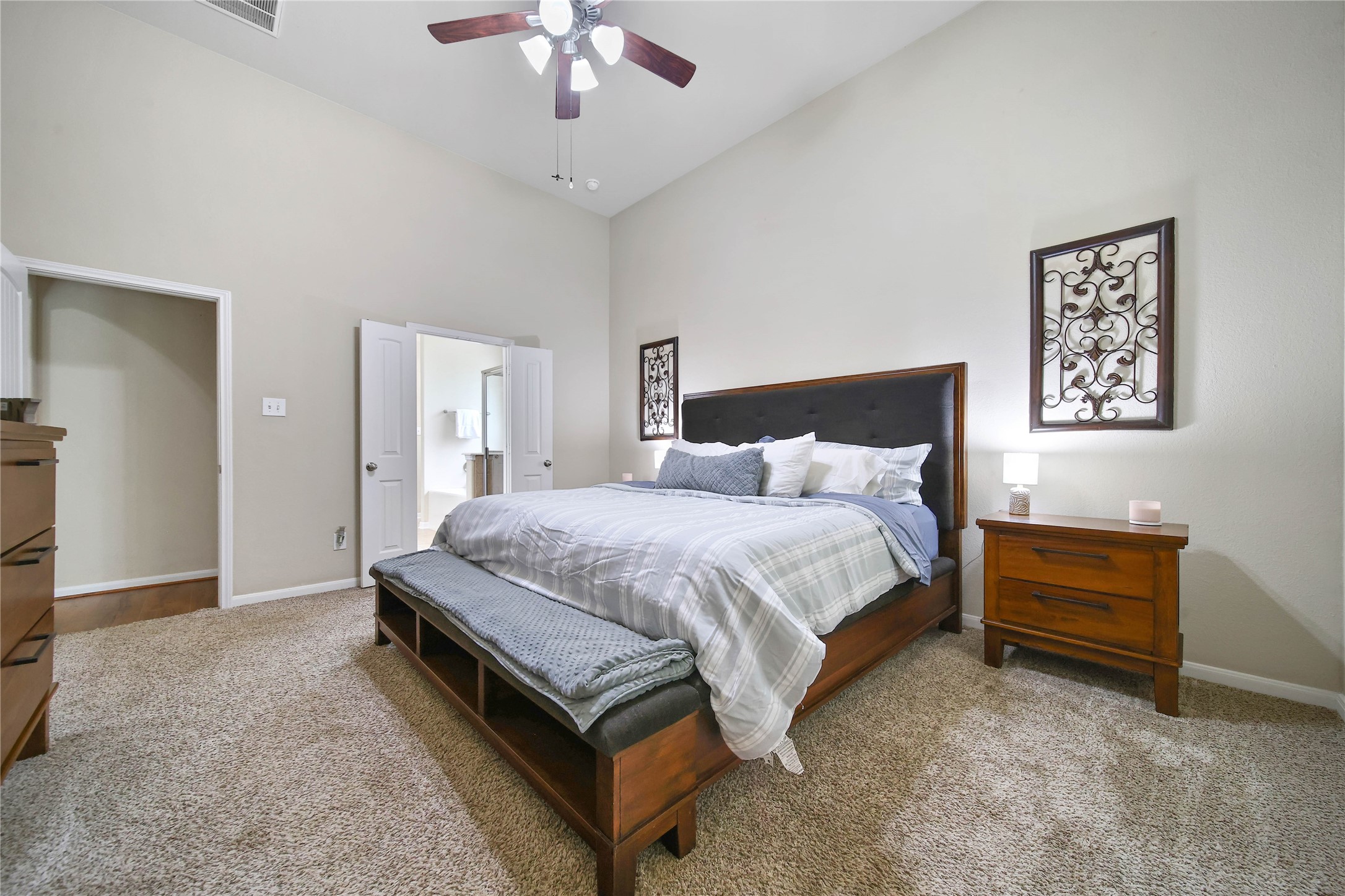 9223 Wapiti Trail Conroe, TX 77303 - Photo 24 of 45 a spacious bedroom with a bed and a chandelier