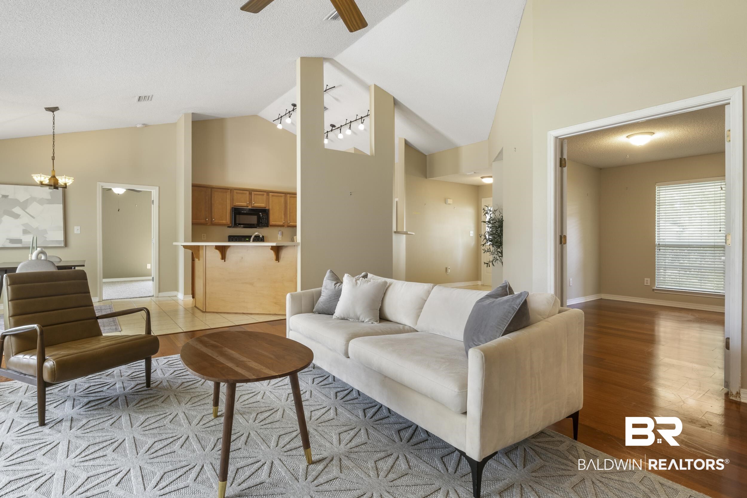 9610 Watkins Drive Fairhope, AL 36532 - Photo 25 of 26 Living room featuring hardwood / wood-style flooring, a textured ceiling, ceiling fan with notable chandelier, and high vaulted ceiling