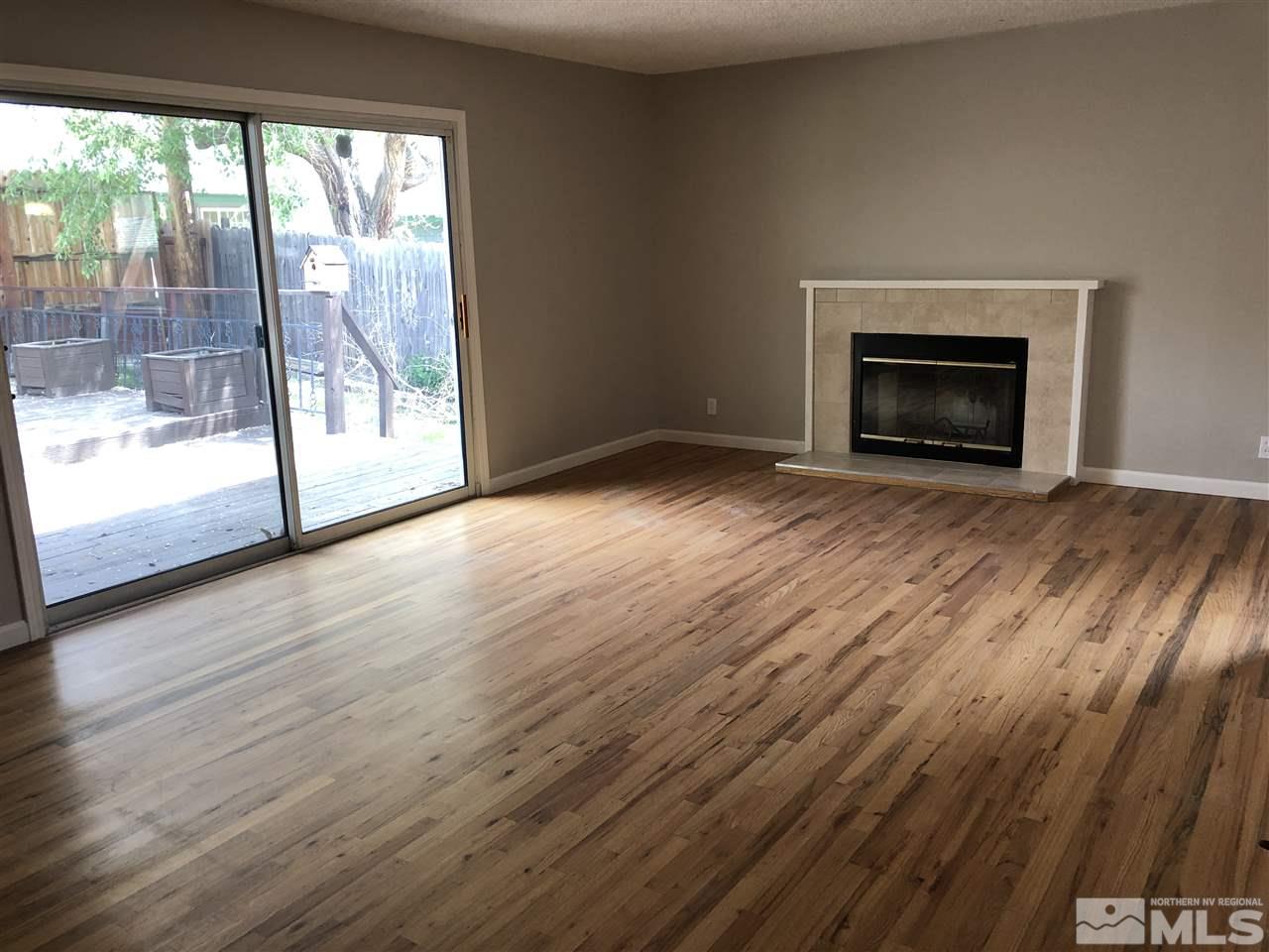 1995 Arcane Avenue Reno, NV 89503 - Photo 2 of 9 a view of empty room with wooden floor and fireplace