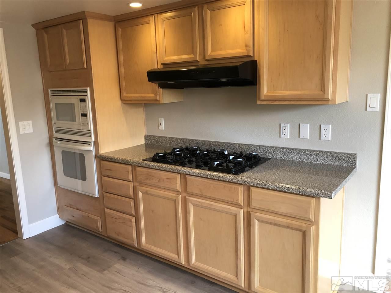 1995 Arcane Avenue Reno, NV 89503 - Photo 5 of 9 a kitchen with granite countertop white cabinets and black appliances