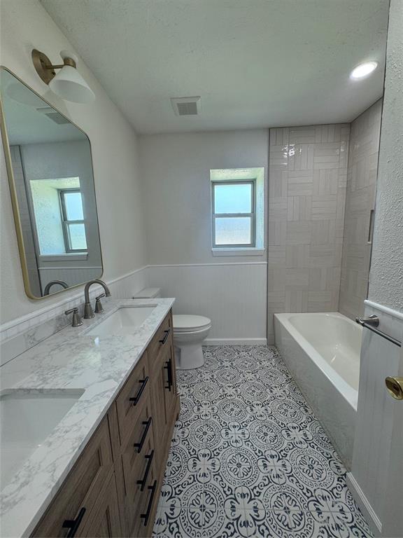 9519 Westpark Drive Benbrook, TX 76126 - Photo 9 of 9 a bathroom with a granite countertop sink a toilet a bathtub and mirror