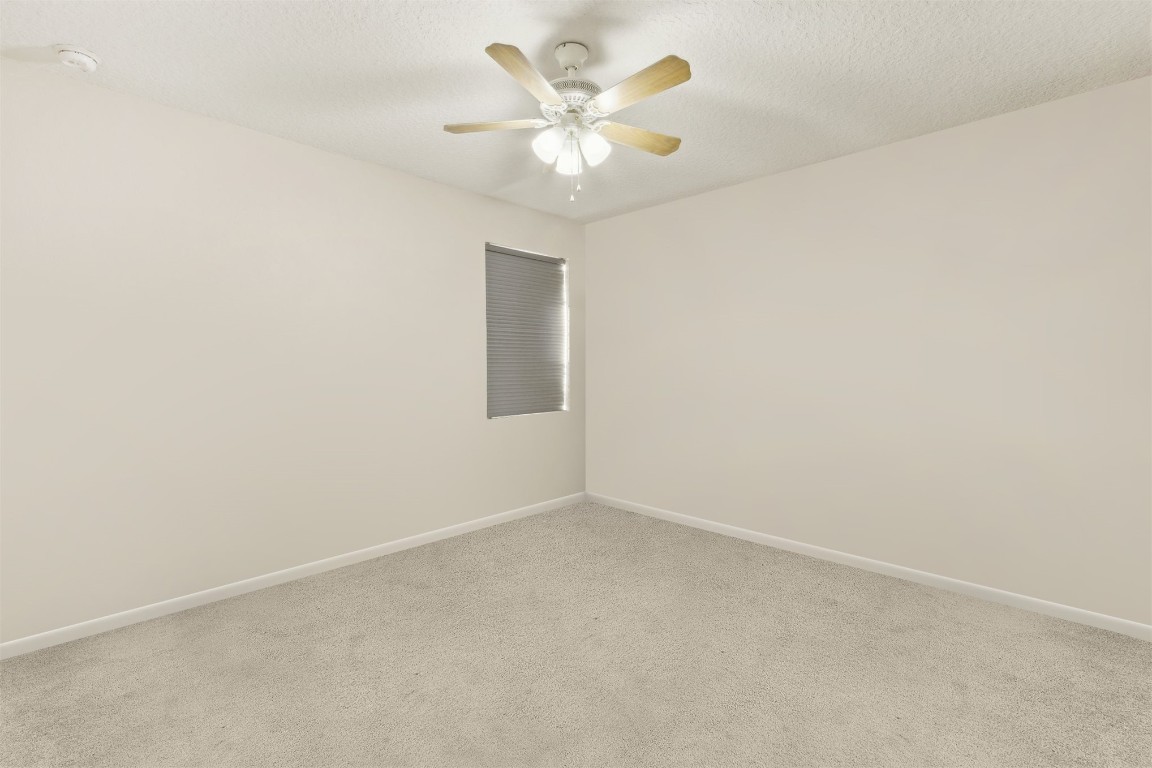 95275 Poplar Way Fernandina Beach, FL 32034 - Photo 22 of 38 an empty room with a chandelier fan and windows