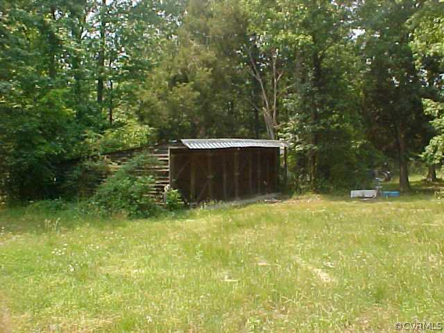 1130 Dispatch Road Quinton, VA 23141 - Photo 4 of 5 a backyard of a house with trees and wooden fence
