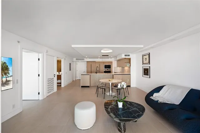 a living room with furniture a dining table and kitchen view