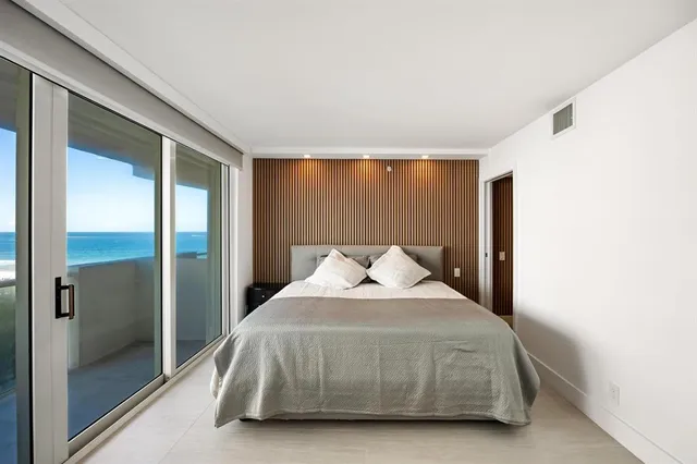 a bedroom with a bed and large mirror