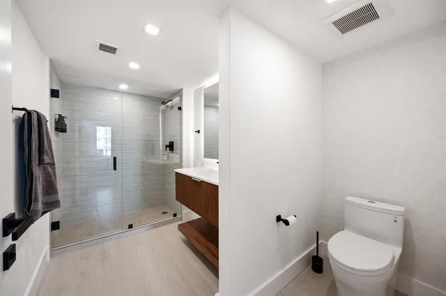 a bathroom with a shower a toilet and a sink