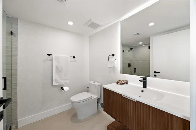 a bathroom with a sink mirror toilet and shower