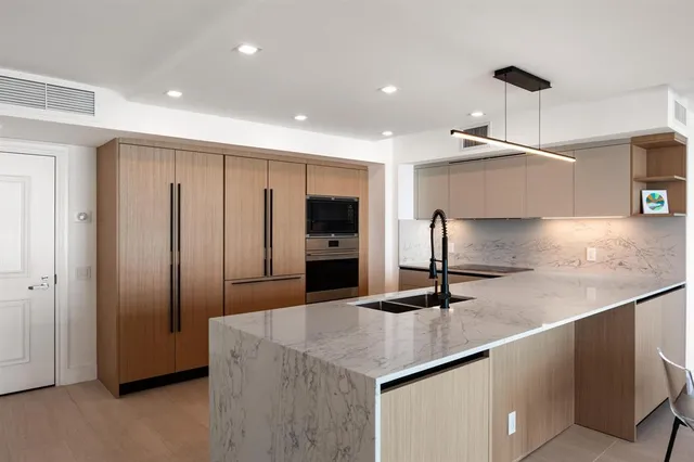 a kitchen with kitchen island a counter top space cabinets and stainless steel appliances