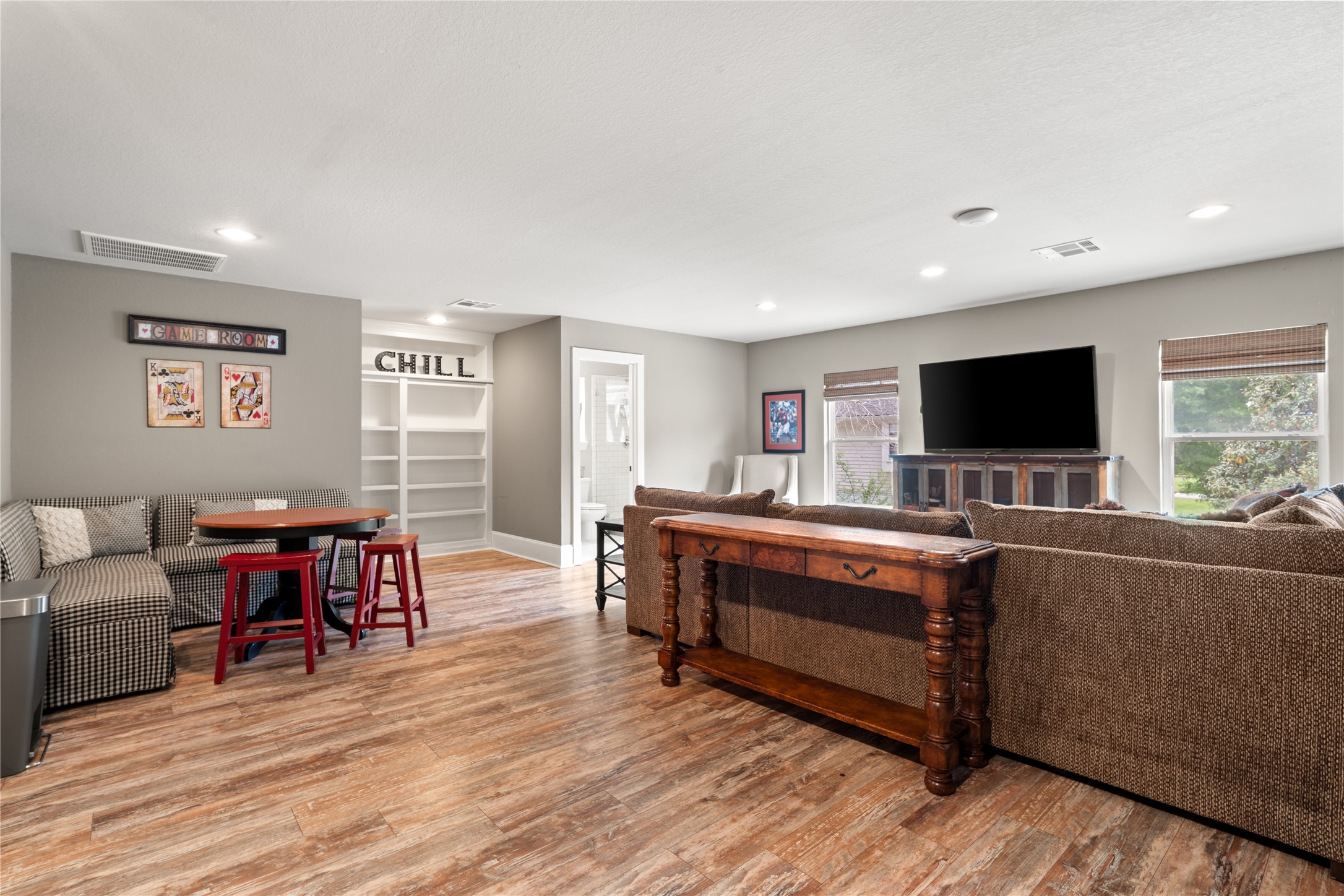 36 Wind River Drive Conroe, TX 77384 - Photo 42 of 45 This spacious living area features top-notch, wood look laminate flooring, ample natural light, and a cozy layout. Kids will love the hidden room behind the "chill bookshelves" or a place to hide your special toys.