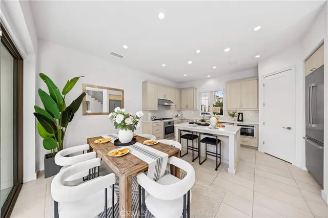 a living room with furniture a potted plant and open kitchen view