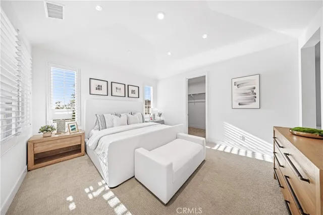 a spacious bedroom with a bed a couch and a window