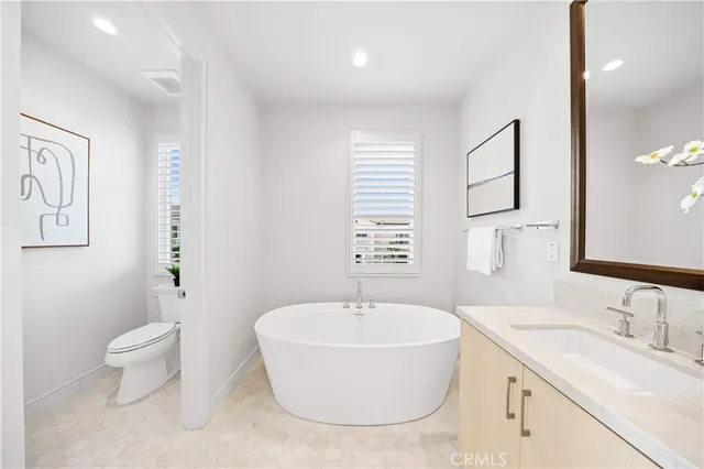 a spacious bathroom with a tub sink and mirror