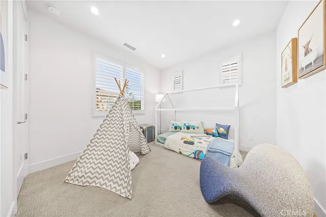 a bedroom with a bed and a potted plant