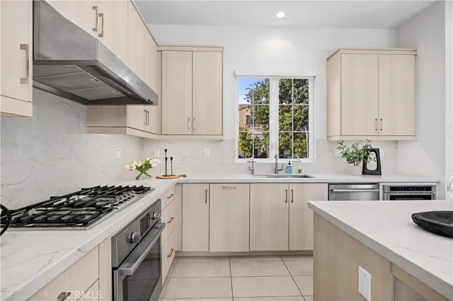 a kitchen with cabinets appliances a sink and a window