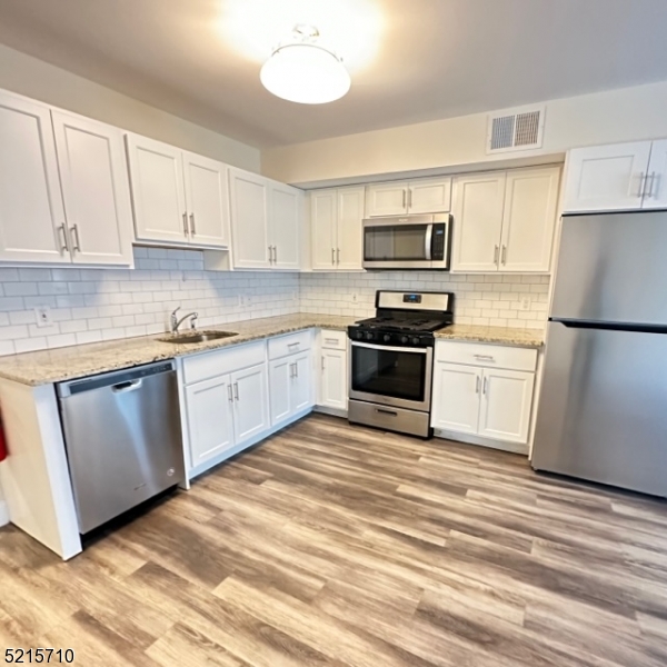 290 3rd Street, Unit D1 Hackensack, NJ 07601 - Photo 8 of 21 a kitchen with granite countertop a refrigerator stove top oven and sink
