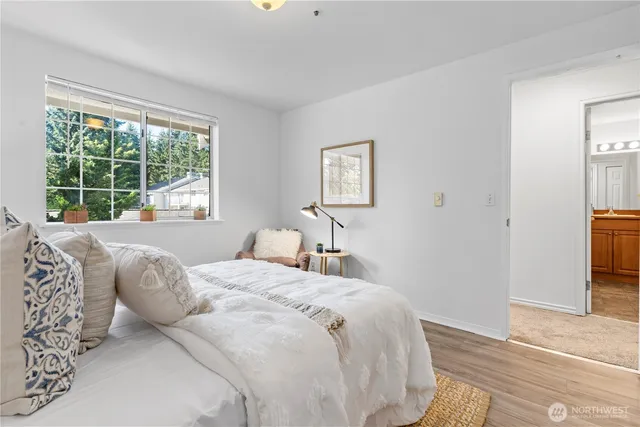 a bedroom with a bed and a large window