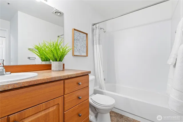 a bathroom with a sink a mirror a potted plant and a bathtub