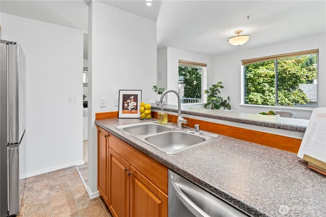 a kitchen with stainless steel appliances granite countertop a sink and a large window