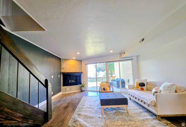 5265 South Rome Beauty Park Murray, UT 84123 - Photo 33 of 35 Living room featuring wood finished floors, a large fireplace, a textured ceiling, and recessed lighting