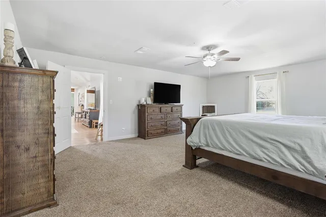 a spacious bedroom with a bed and a flat screen tv