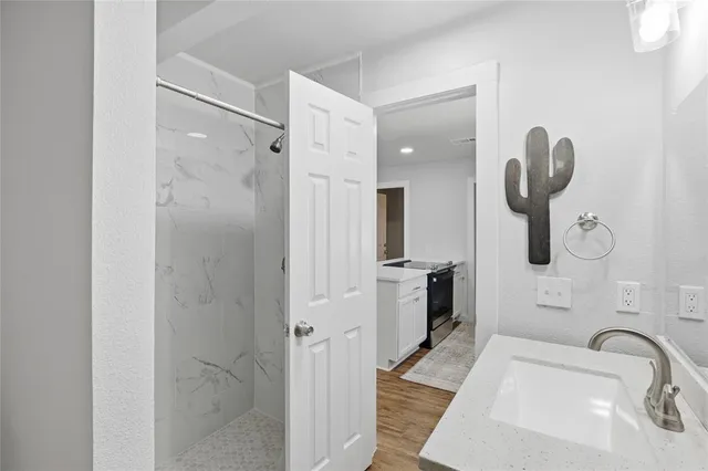 a bathroom with a sink a toilet and shower