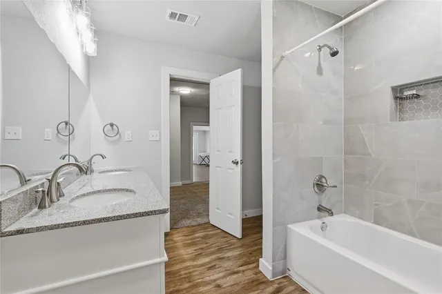 a bathroom with a granite countertop tub sink and mirror