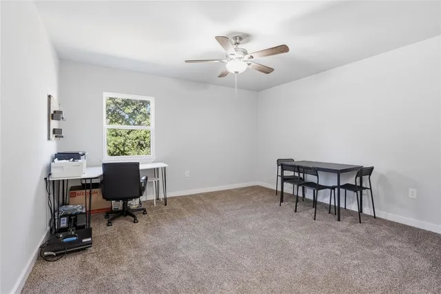 a view of a workspace with furniture and a window