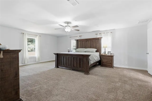 a bedroom with a bed chandelier and a window