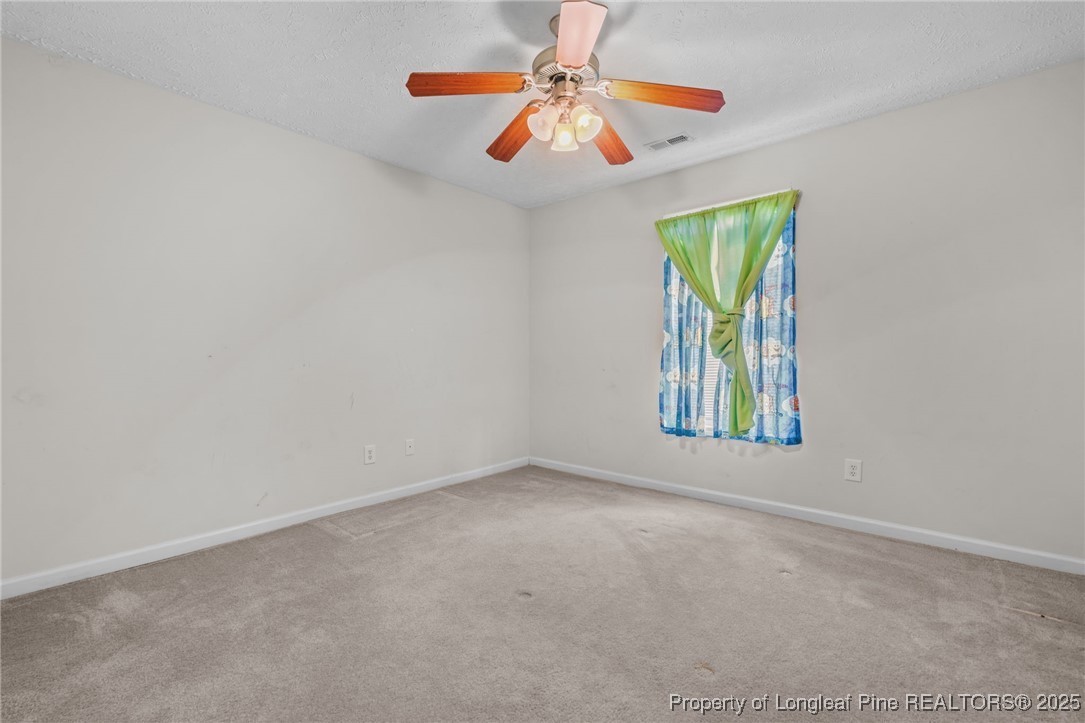 117 Usher Court Raeford, NC 28376 - Photo 28 of 48 an empty room with windows and chandelier fan