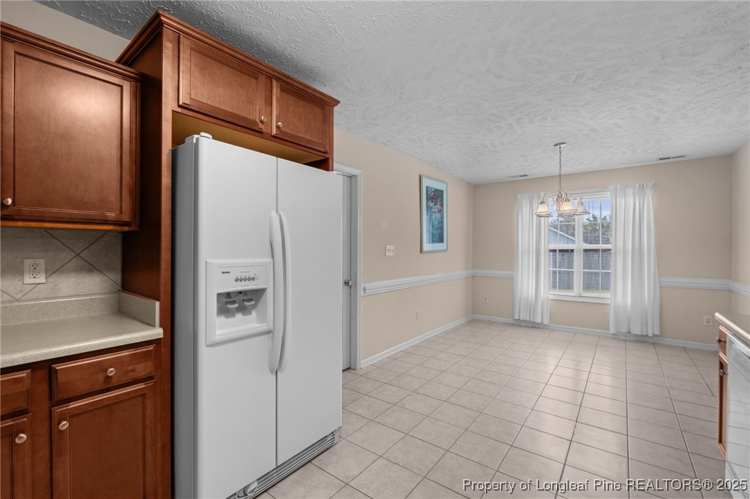 117 Usher Court Raeford, NC 28376 - Photo 47 of 48 a view of a refrigerator in kitchen and an empty room in wooden floor