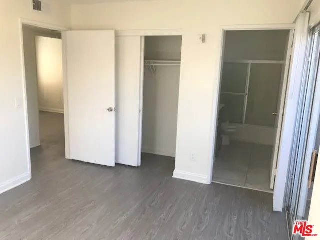 an empty room with wooden floor and closet
