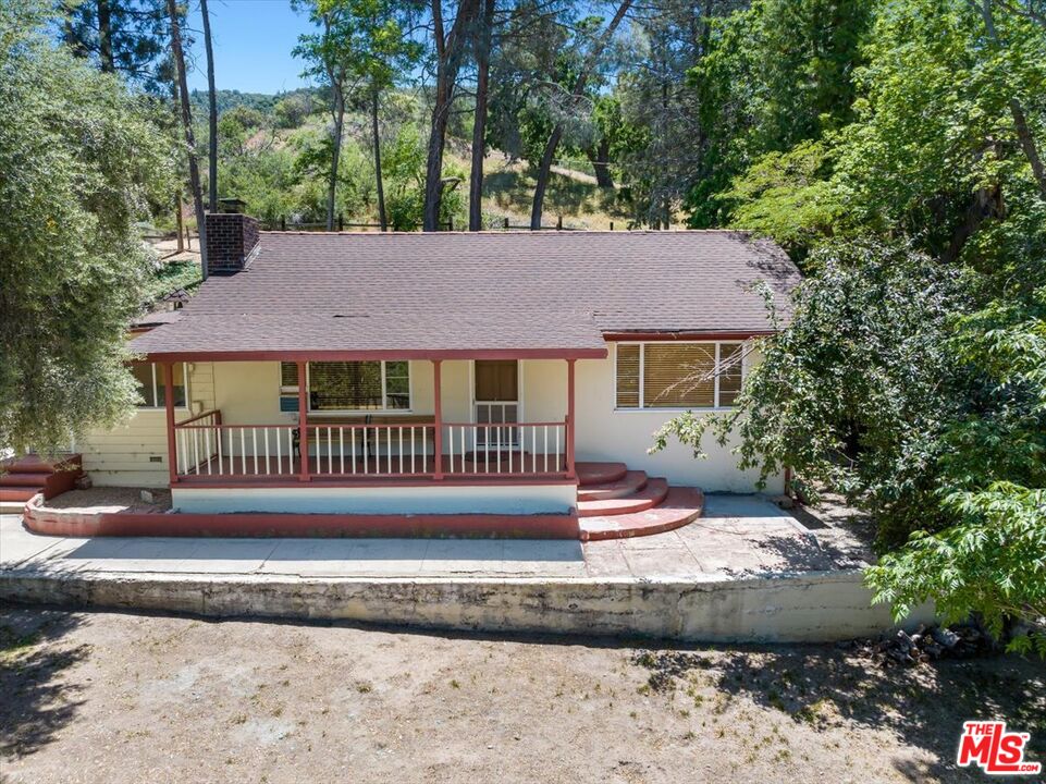 31008 Pine Canyon Road Lake Hughes, CA 93532 - Photo 20 of 29 a front view of a house with a garden and deck