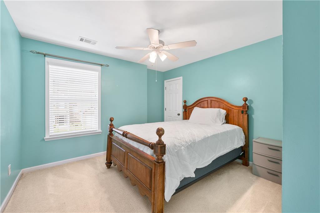 871 New Liberty Way Braselton, GA 30517 - Photo 30 of 47 a bedroom with a bed and a chandelier