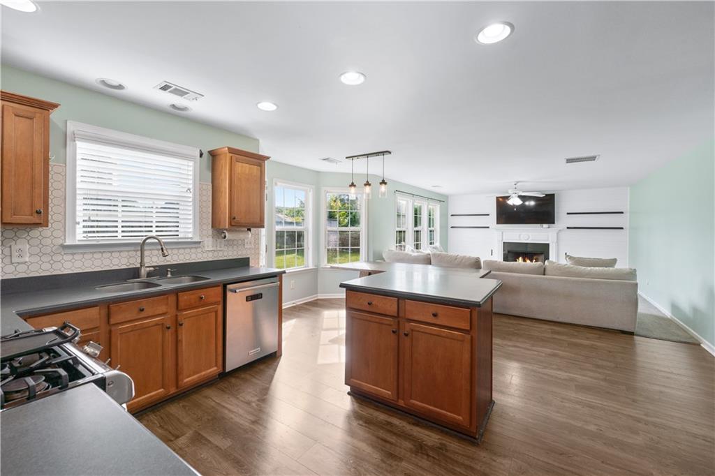 871 New Liberty Way Braselton, GA 30517 - Photo 8 of 47 a large kitchen with stainless steel appliances granite countertop a sink and wooden floors