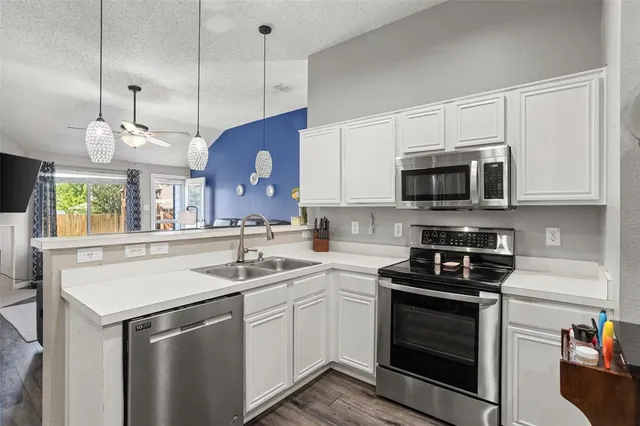 a kitchen with kitchen island granite countertop a sink a stove and microwave