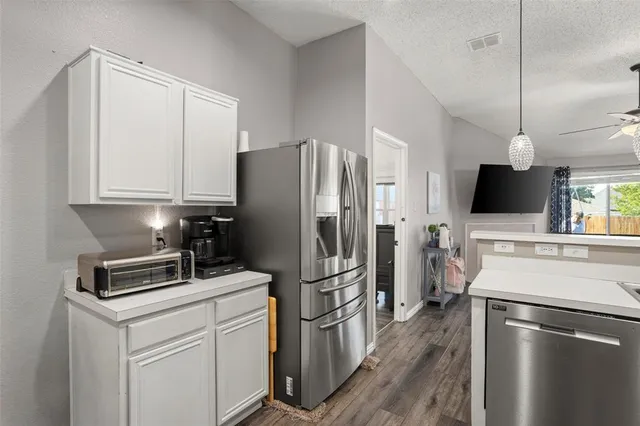 a kitchen with a refrigerator microwave and stove top oven