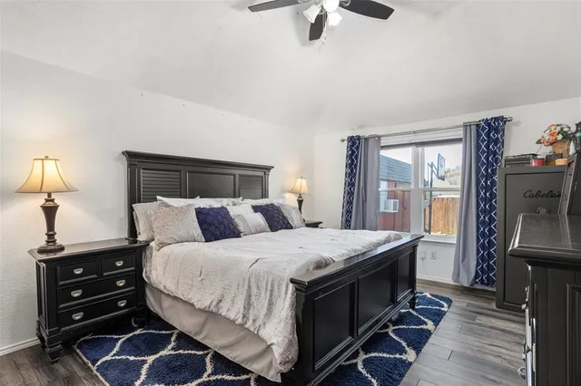 a bedroom with a bed and a flat tv screen on a dresser