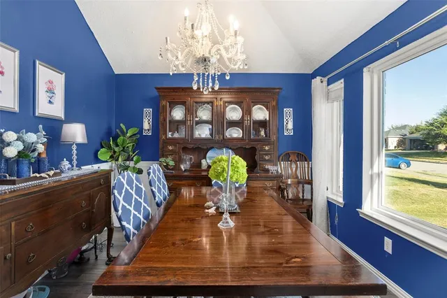 a view of a dining room with furniture a chandelier and wooden floor